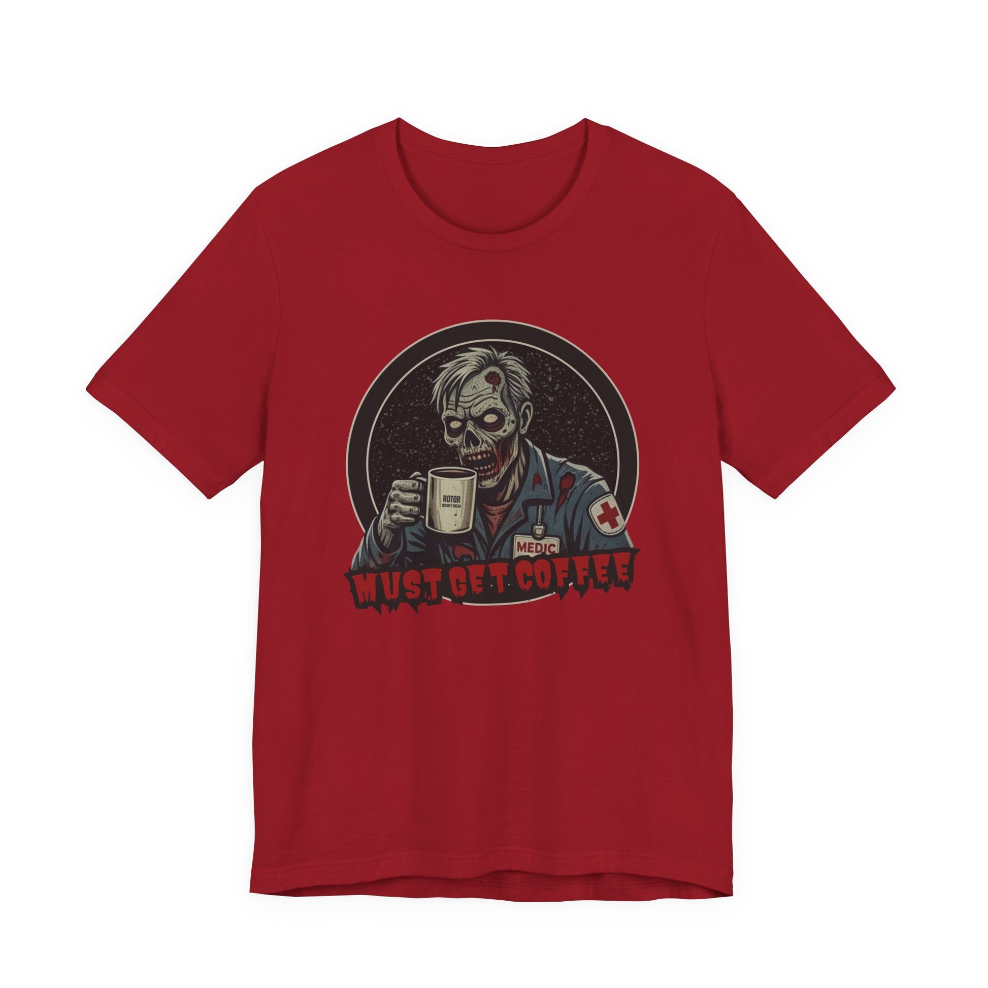 A red crewneck t-shirt featuring a graphic of a zombie medic holding a coffee mug with the text 'MUST GET COFFEE!' in red by Rotor Wash & Wear