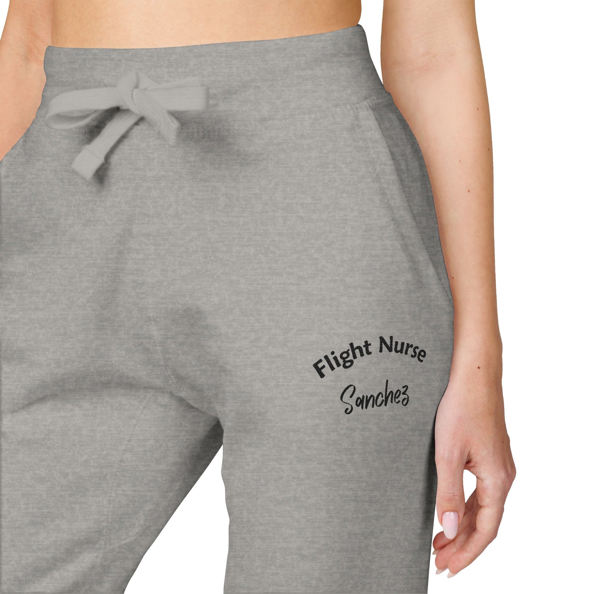 Gray joggers with embroidered 'Flight Nurse Sanchez' text on the thigh against a white background