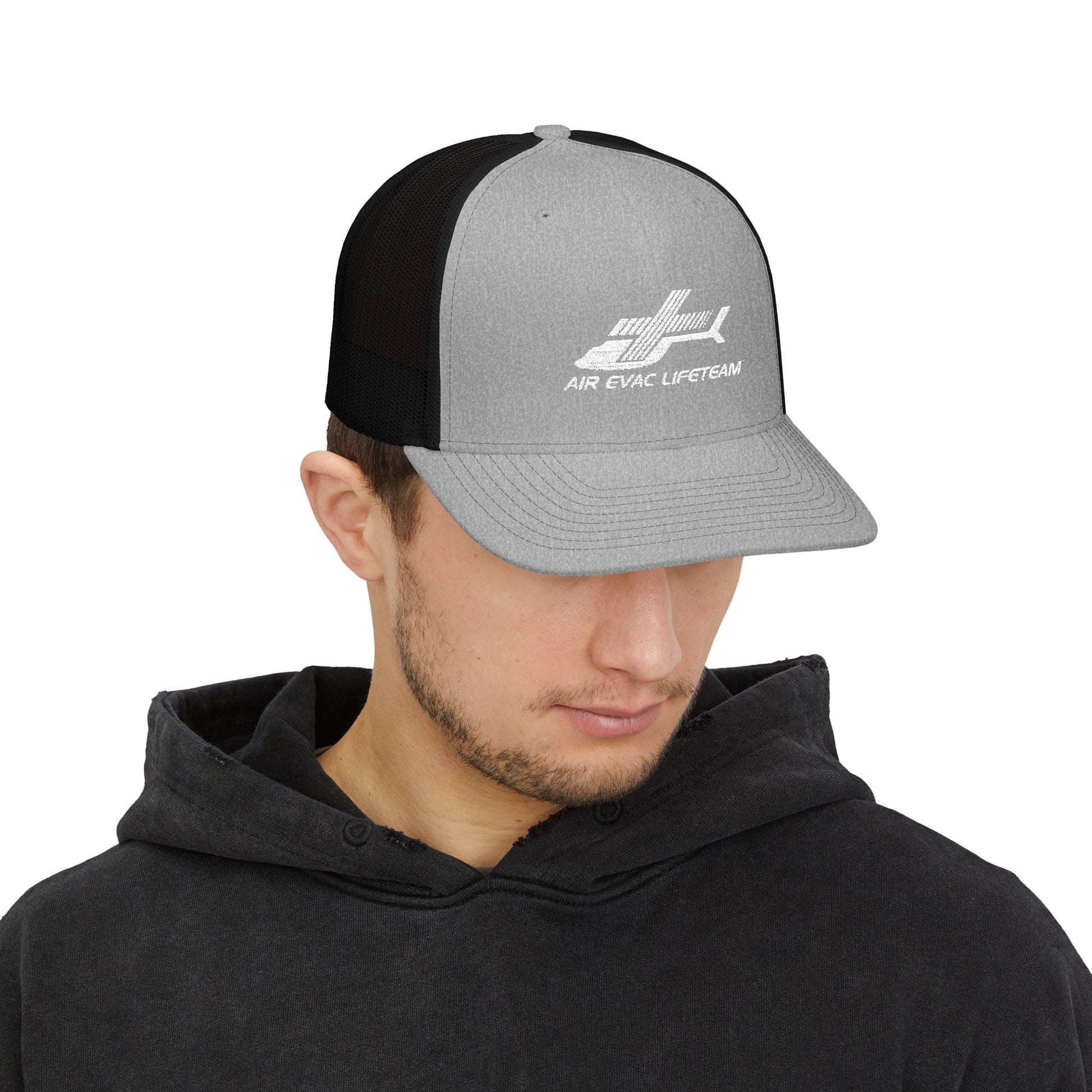 Man wearing gray and black Richardson 112 trucker hat with 'Air Evac Lifeteam' logo by Rotor Wash & Wear