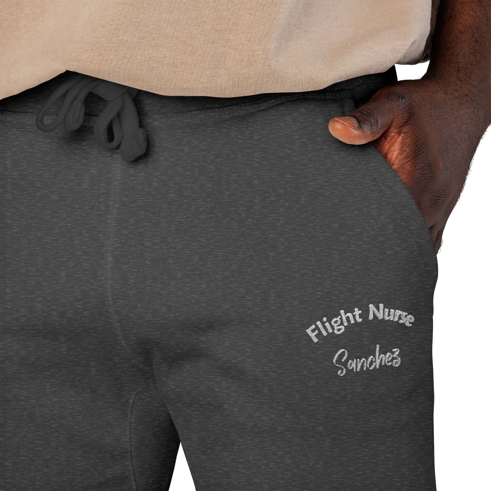 Dark gray joggers with embroidered 'Flight Nurse Sanchez' text on the thigh against a white background