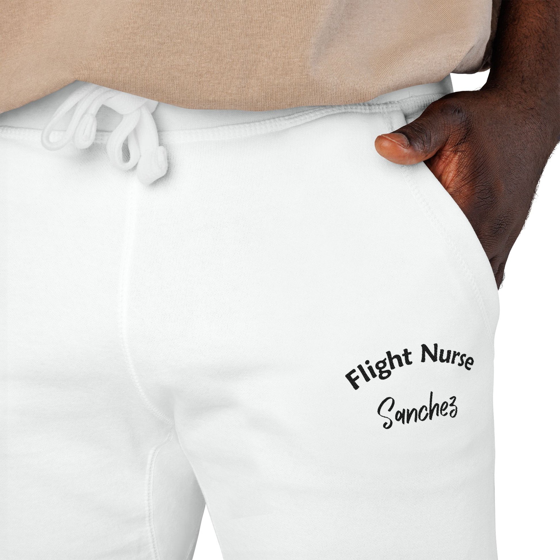 White joggers with embroidered 'Flight Nurse Sanchez' text on the thigh against a white background