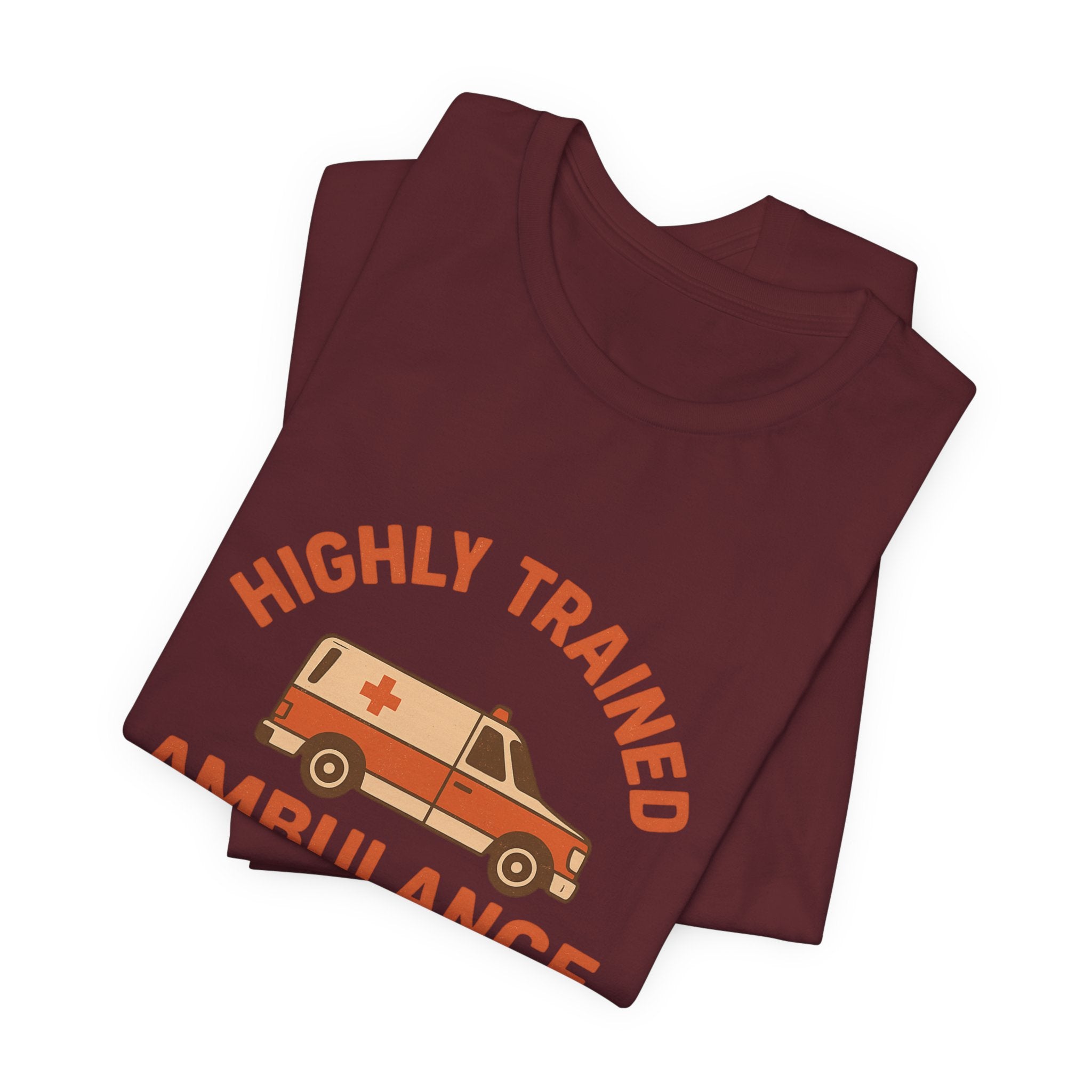 Folded maroon t-shirt with 'Highly Trained' and ambulance graphic on a white background