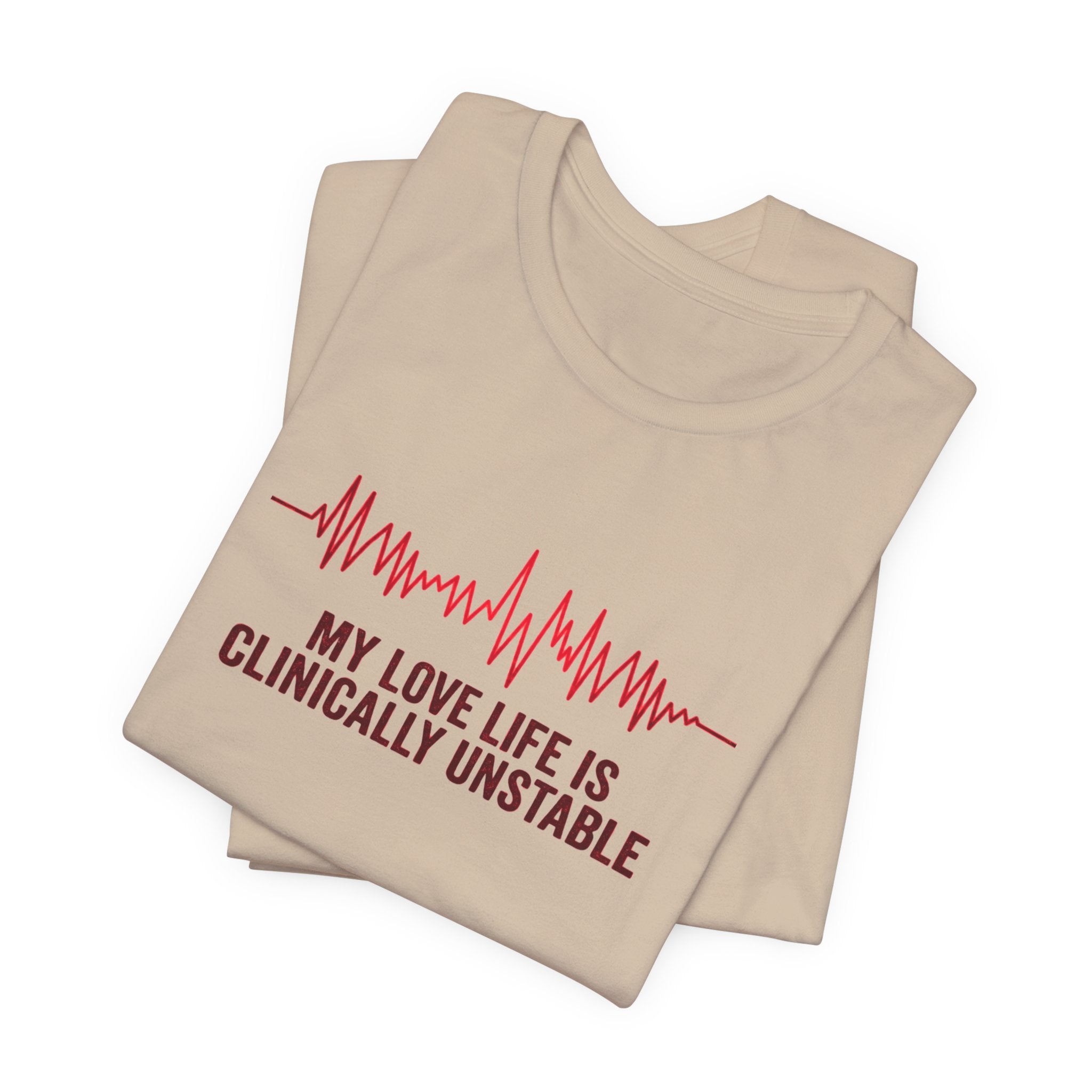 Folded tan t-shirt ventricular fibrillation cardiac rhythm and text "My love life is clinically unstable" by Rotor Wash & Wear