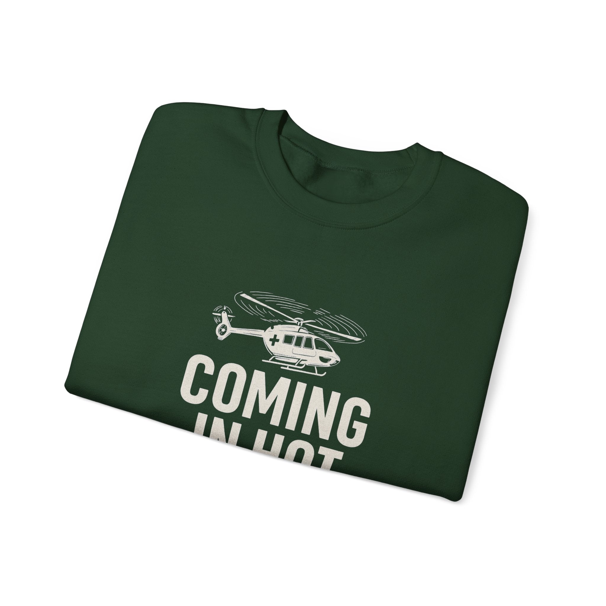 Folded green sweatshirt with helicopter graphic and text 'COMING IN HOT' by Rotor Wash & Wear
