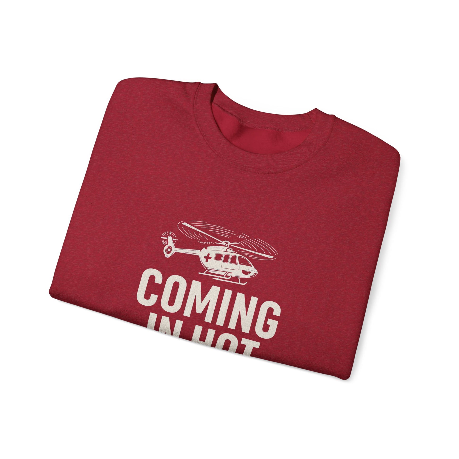 Folded red sweatshirt with helicopter graphic and text 'COMING IN HOT' by Rotor Wash & Wear