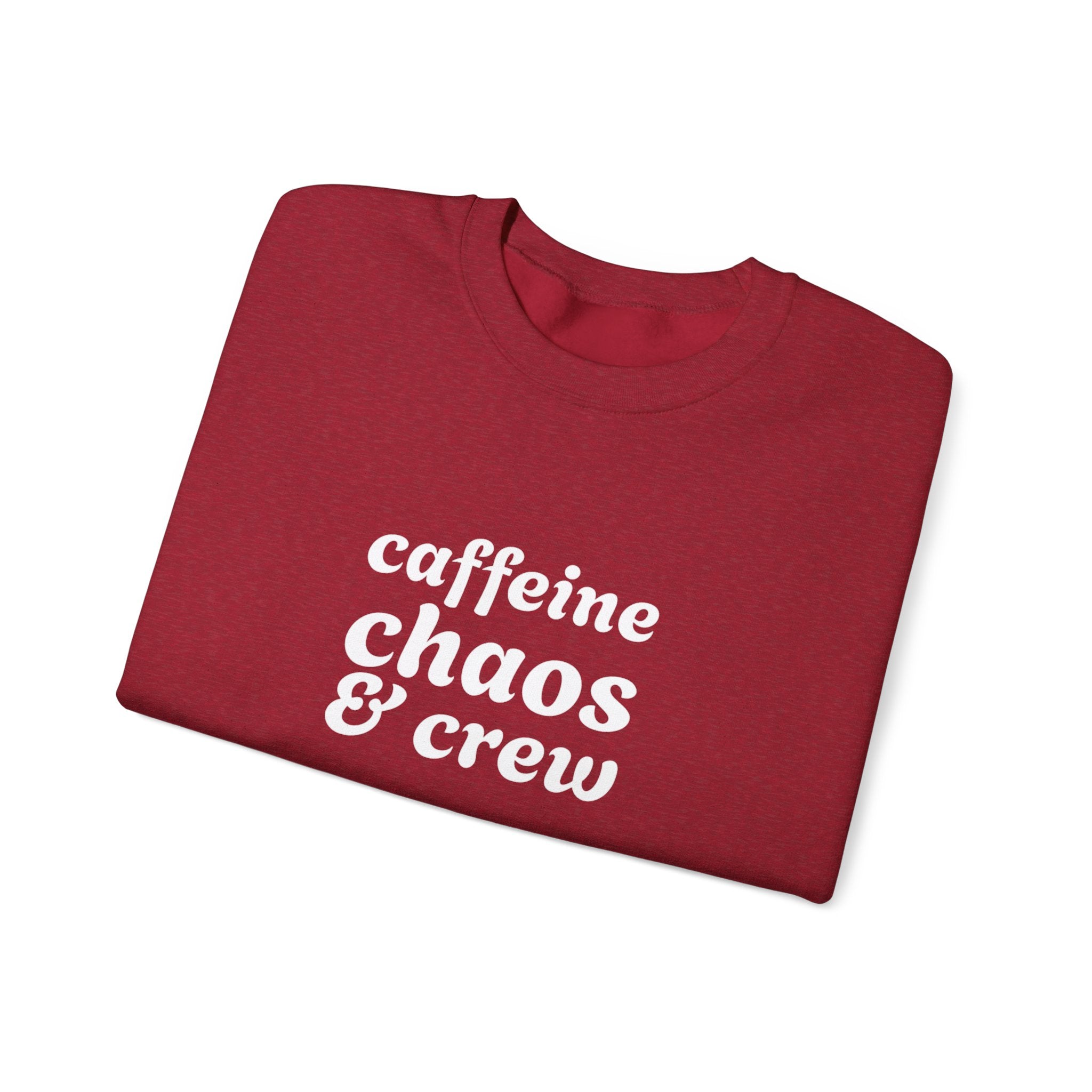 Folded red sweatshirt with 'caffeine chaos & crew' text on by Rotor Wash & Wear