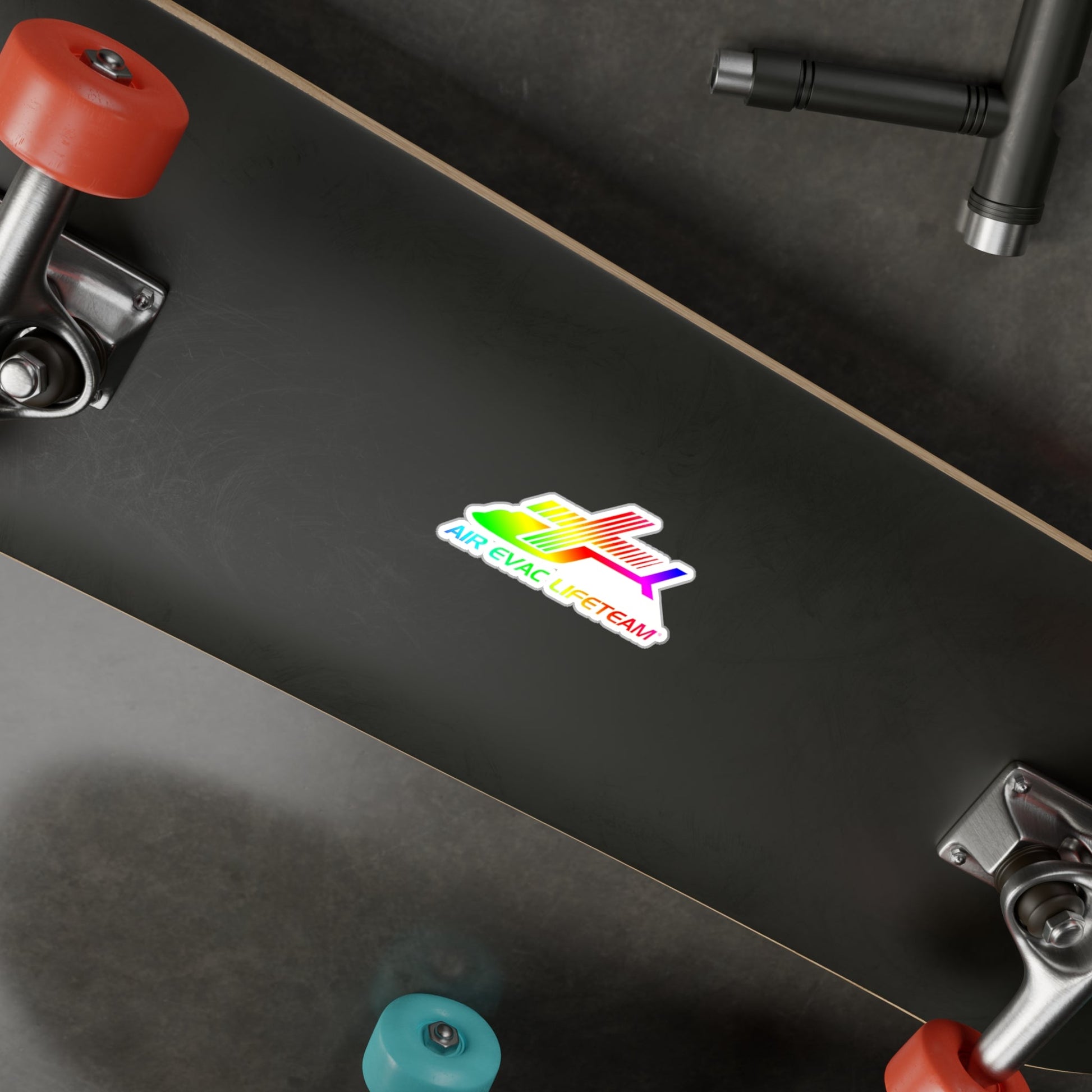 Black skateboard with a colorful "Air Evac Lifeteam" sticker on a dark surface