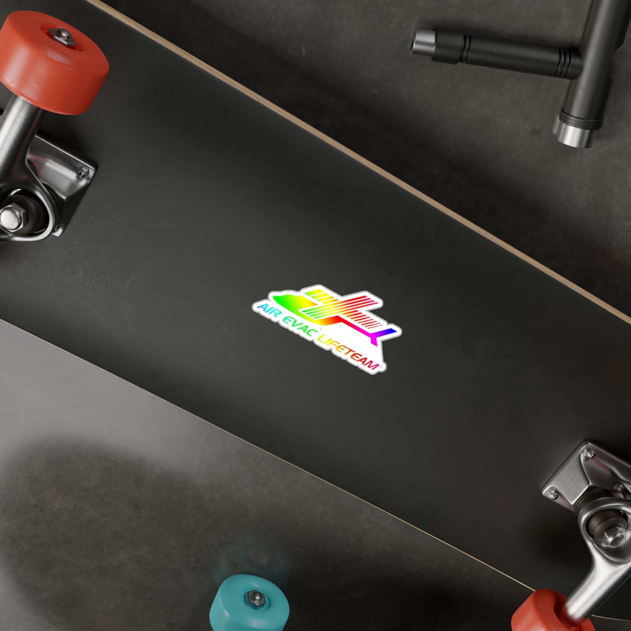 Black skateboard with a colorful "Air Evac Lifeteam" sticker on a dark surface