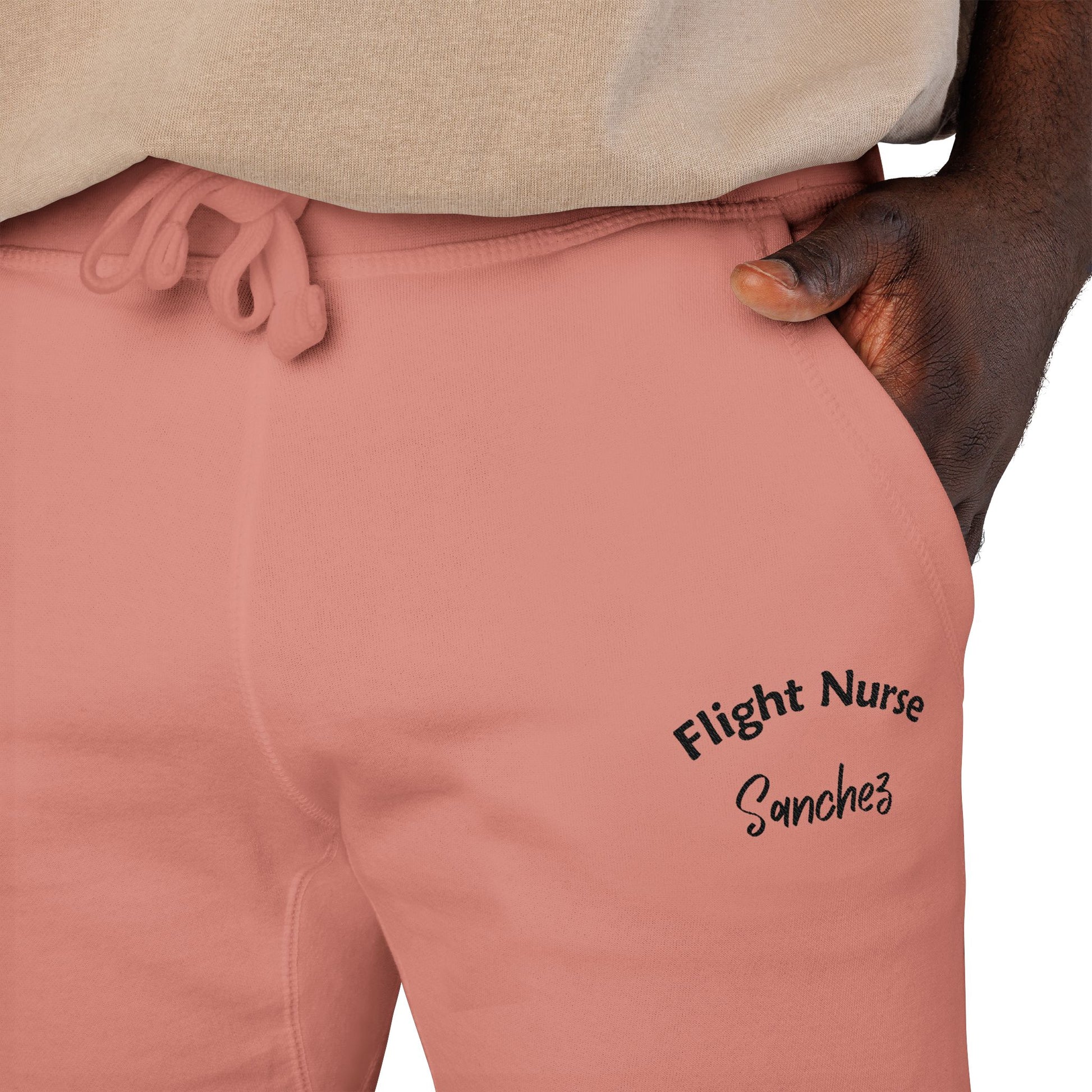 Pink joggers with embroidered 'Flight Nurse Sanchez' text on the thigh against a white background