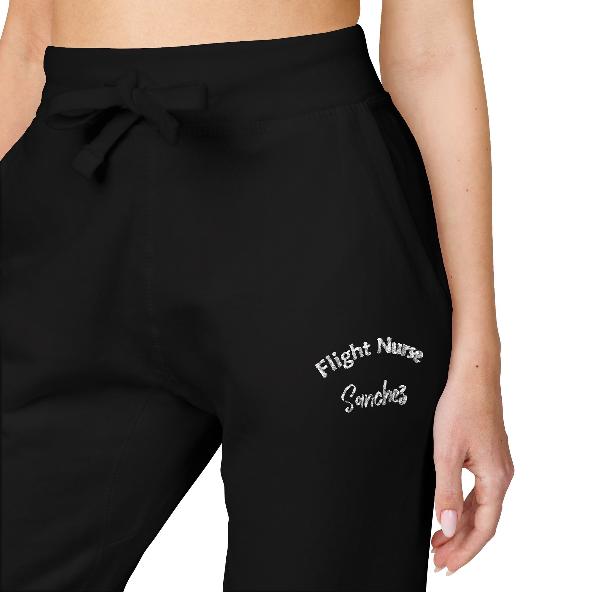 Black joggers with embroidered 'Flight Nurse Sanchez' text on the thigh against a white background