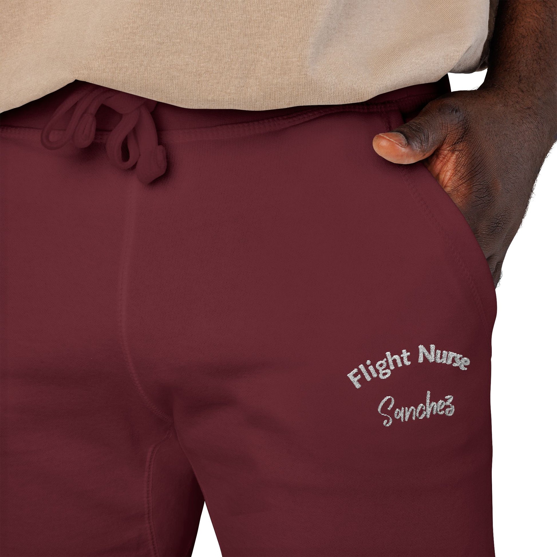 Maroon joggers with embroidered 'Flight Nurse Sanchez' text on the thigh against a white background