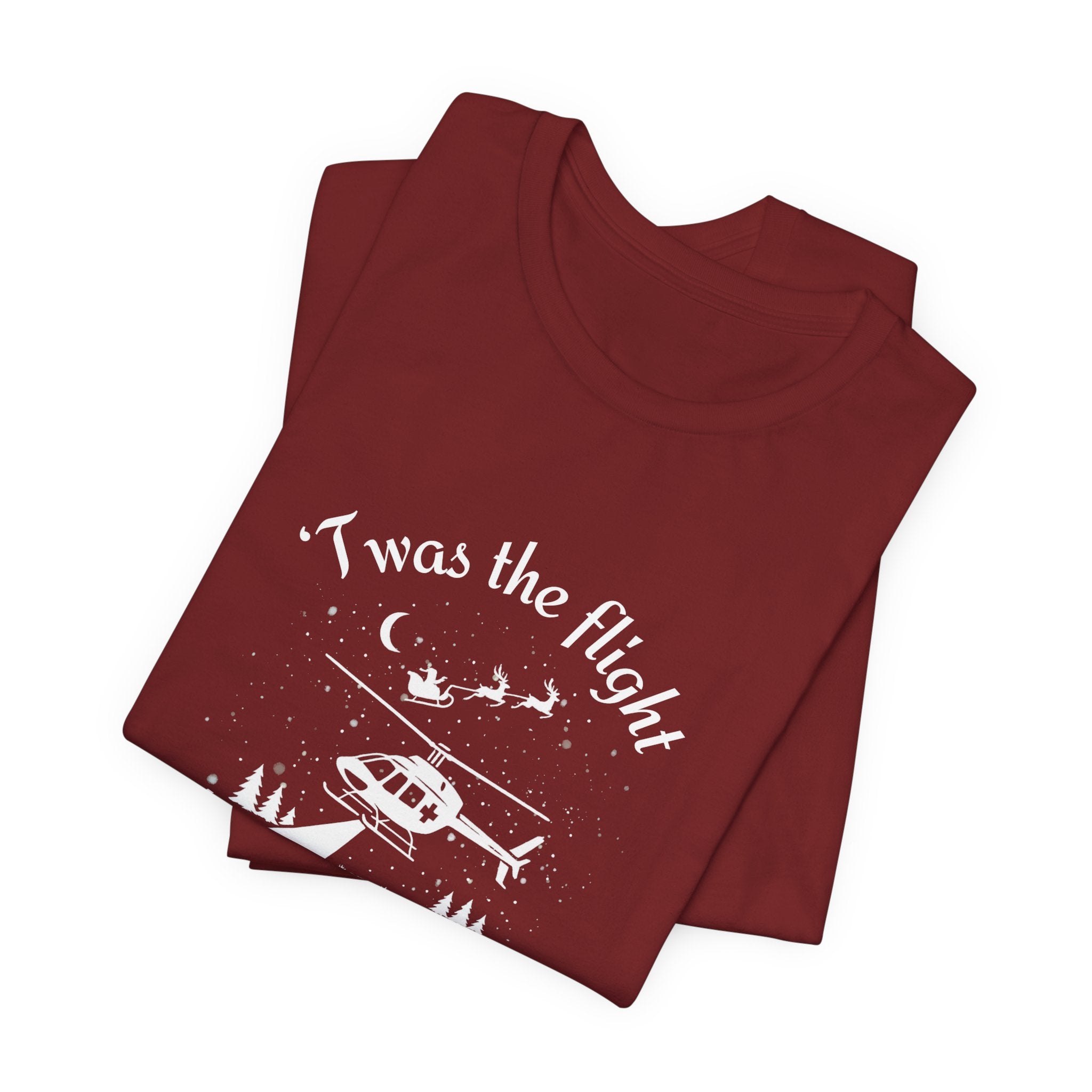 Folded dark red t-shirt with helicopter graphic and Santa and his sleigh in the background with text "'Twas the flight before Christmas" by Rotor Wash & Wear
