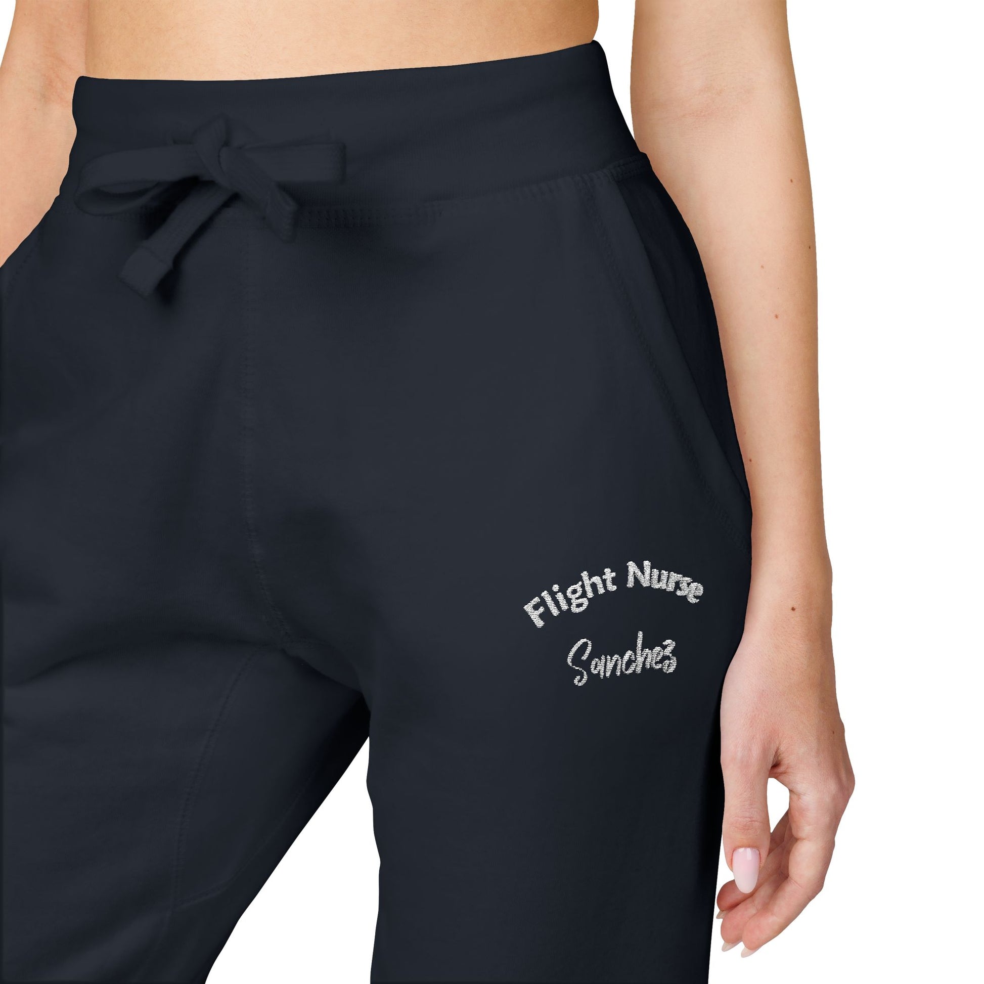 Black joggers with embroidered 'Flight Nurse Sanchez' text on the thigh against a white background