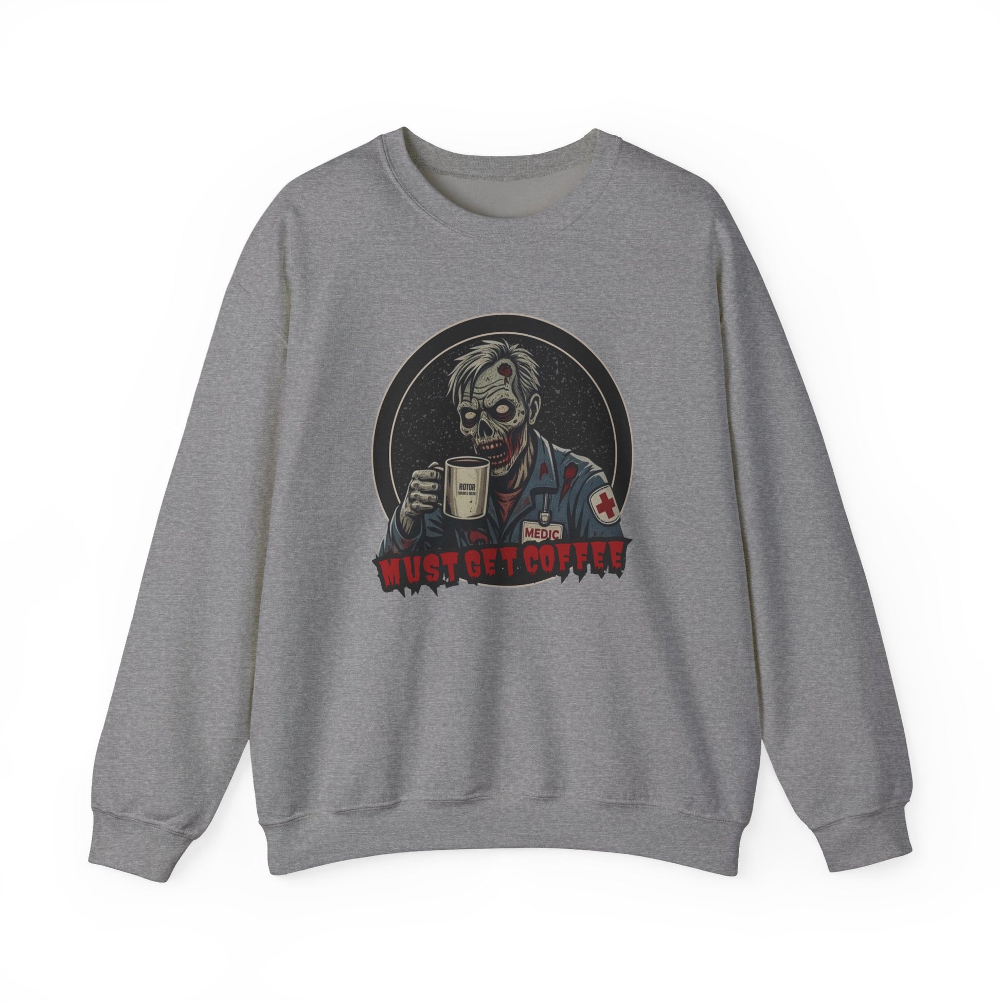 A heather gray crewneck sweatshirt featuring a graphic print of a zombie in a medical uniform holding a coffee mug, with the text 'MUST GET COFFEE' below it by Rotor Wash & Wear