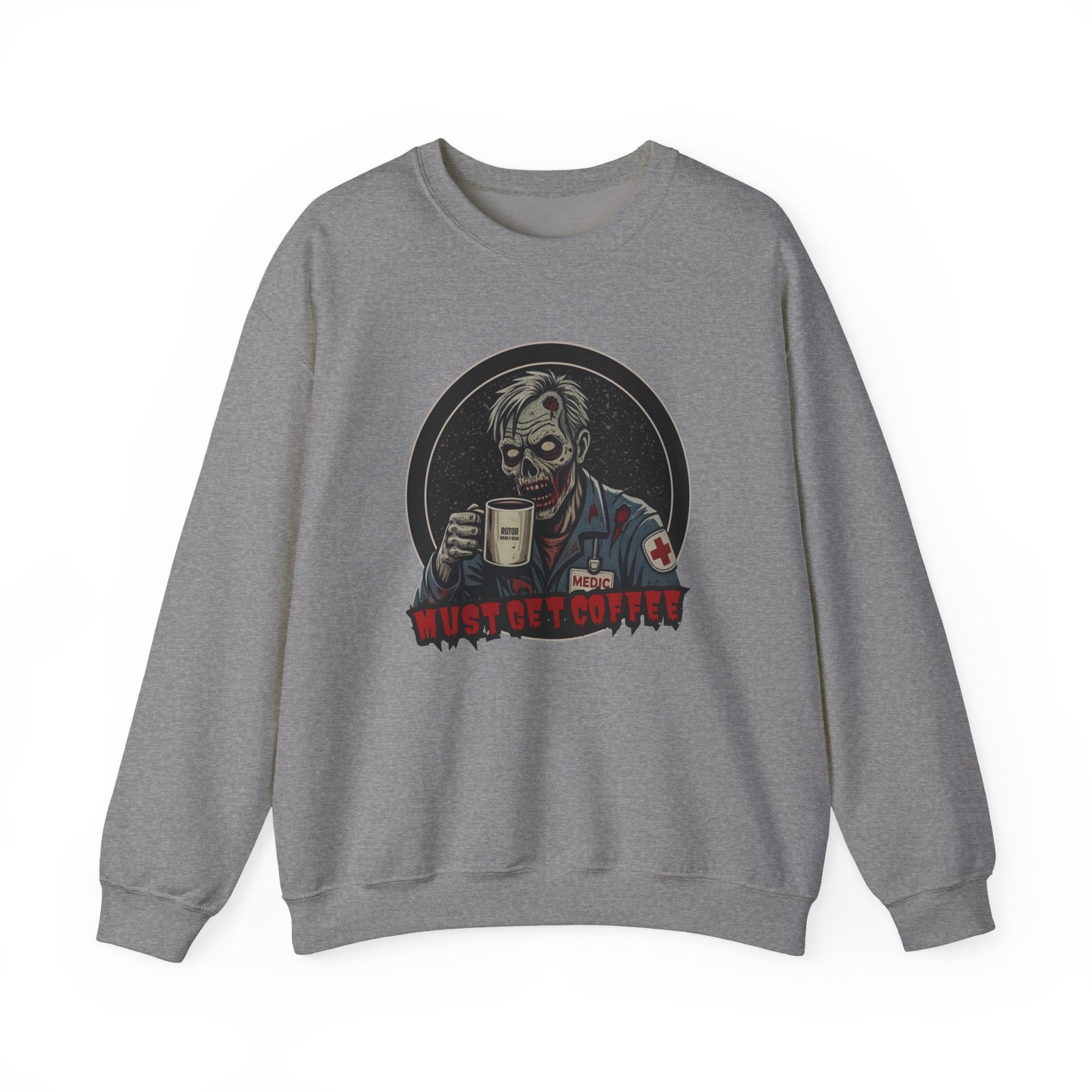A heather gray crewneck sweatshirt featuring a graphic print of a zombie in a medical uniform holding a coffee mug, with the text 'MUST GET COFFEE' below it by Rotor Wash & Wear