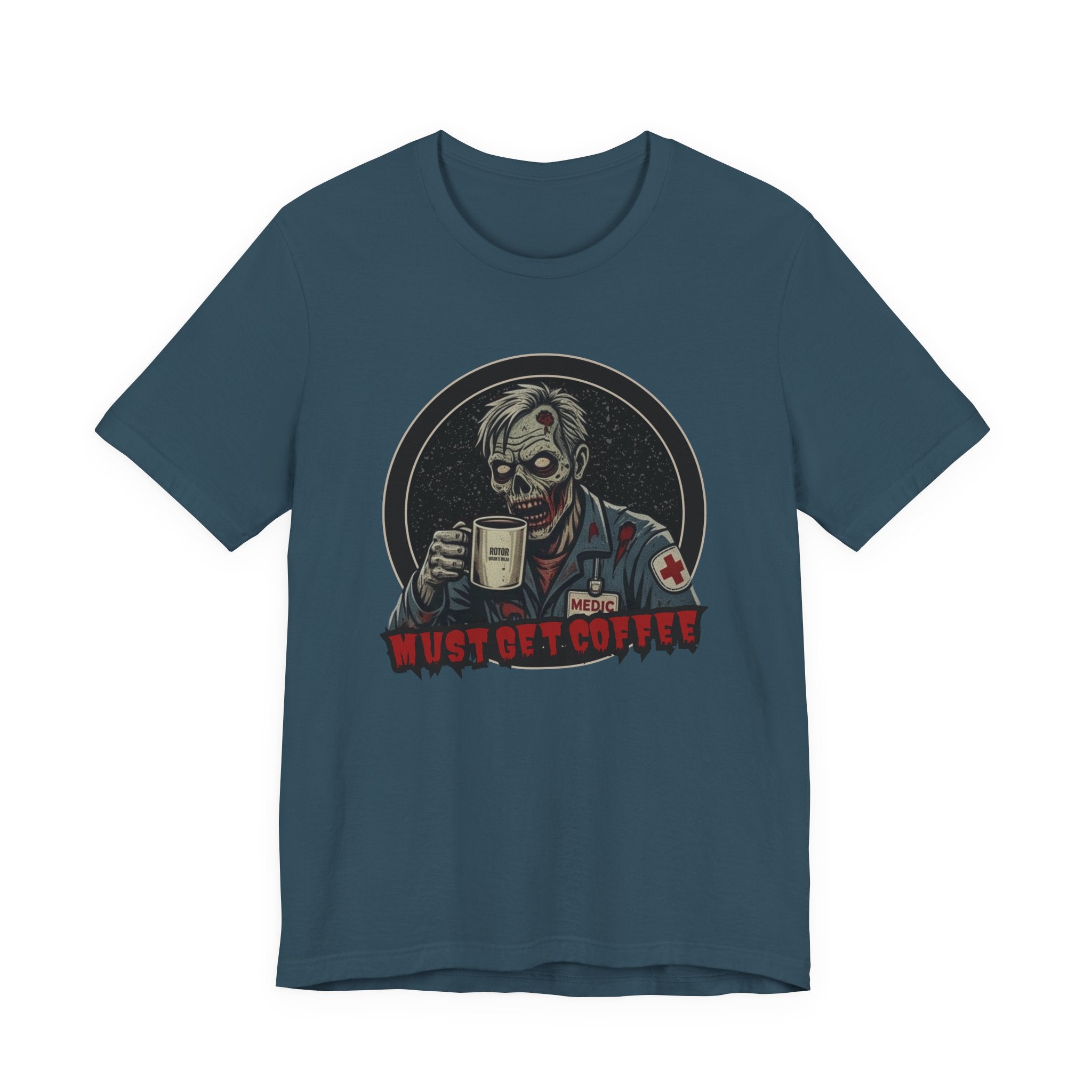 A dark teal crewneck t-shirt featuring a graphic of a zombie medic holding a coffee mug with the text 'MUST GET COFFEE!' in red by Rotor Wash & Wear