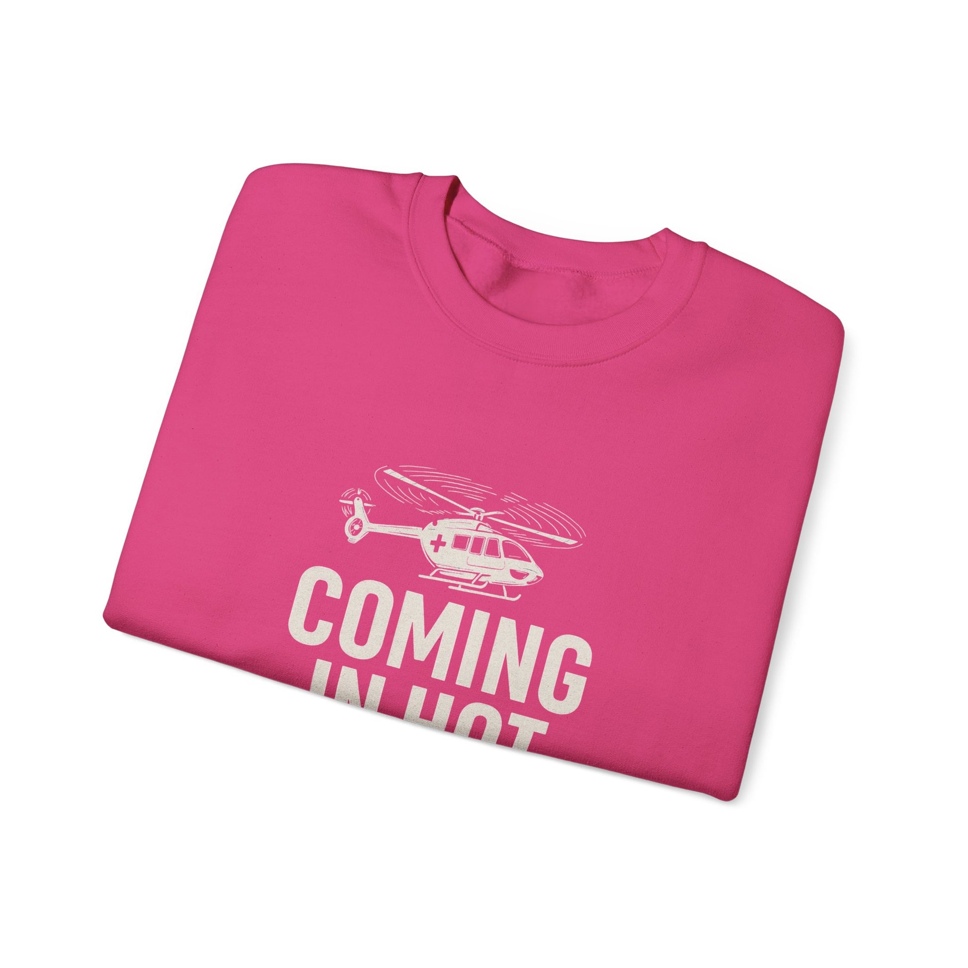 Folded pink sweatshirt with helicopter graphic and text 'COMING IN HOT' by Rotor Wash & Wear