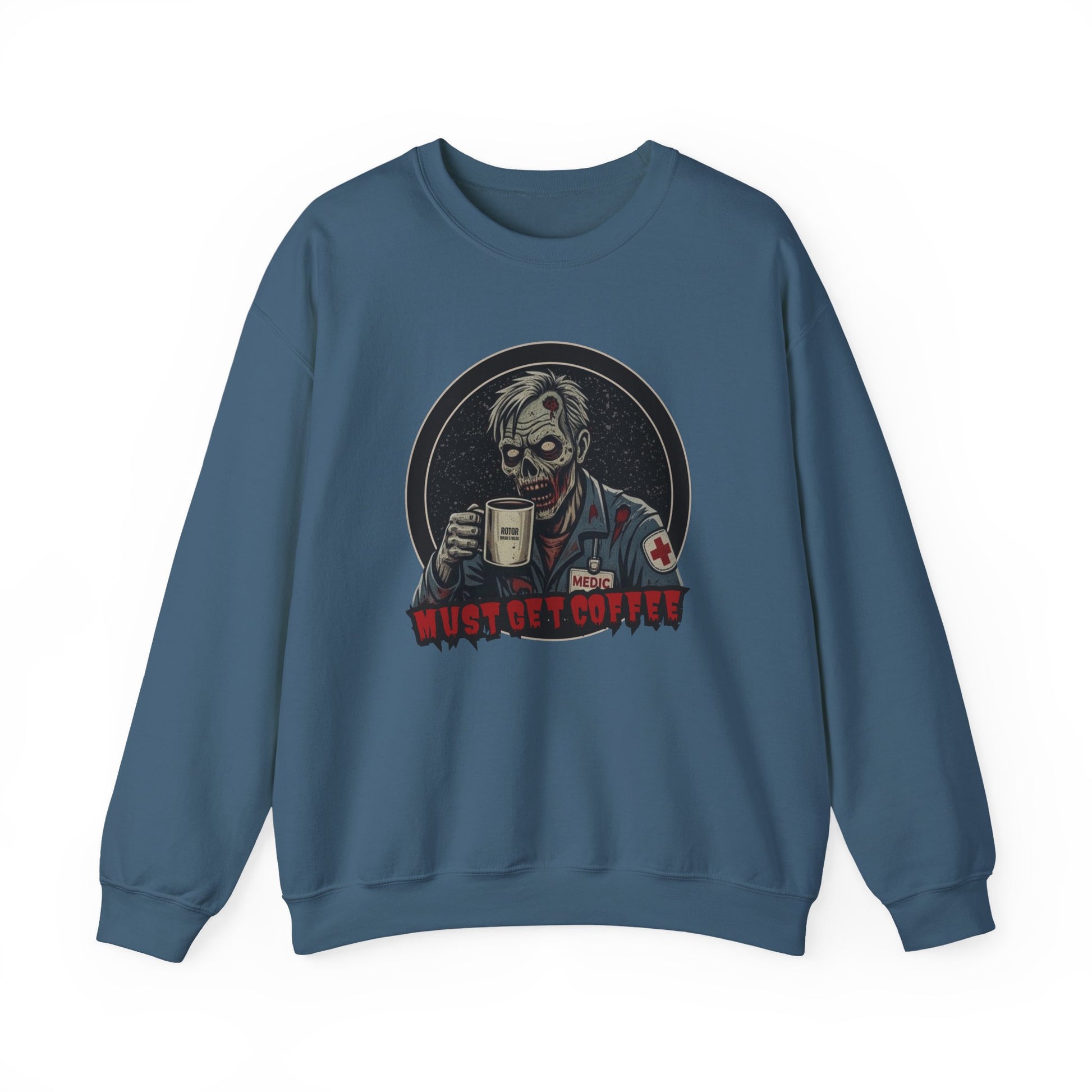 A deep teal crewneck sweatshirt featuring a graphic print of a zombie in a medical uniform holding a coffee mug, with the text 'MUST GET COFFEE' below it by Rotor Wash & Wear