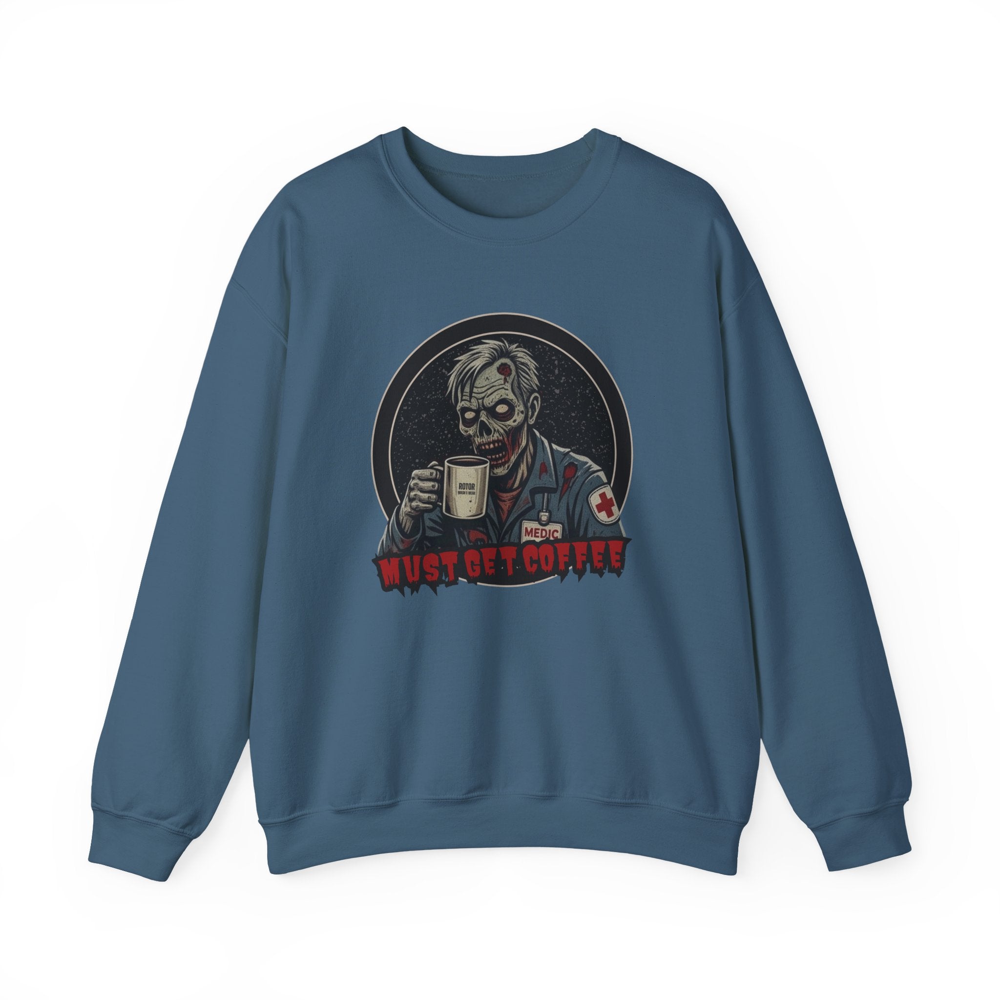 A deep teal crewneck sweatshirt featuring a graphic print of a zombie in a medical uniform holding a coffee mug, with the text 'MUST GET COFFEE' below it by Rotor Wash & Wear