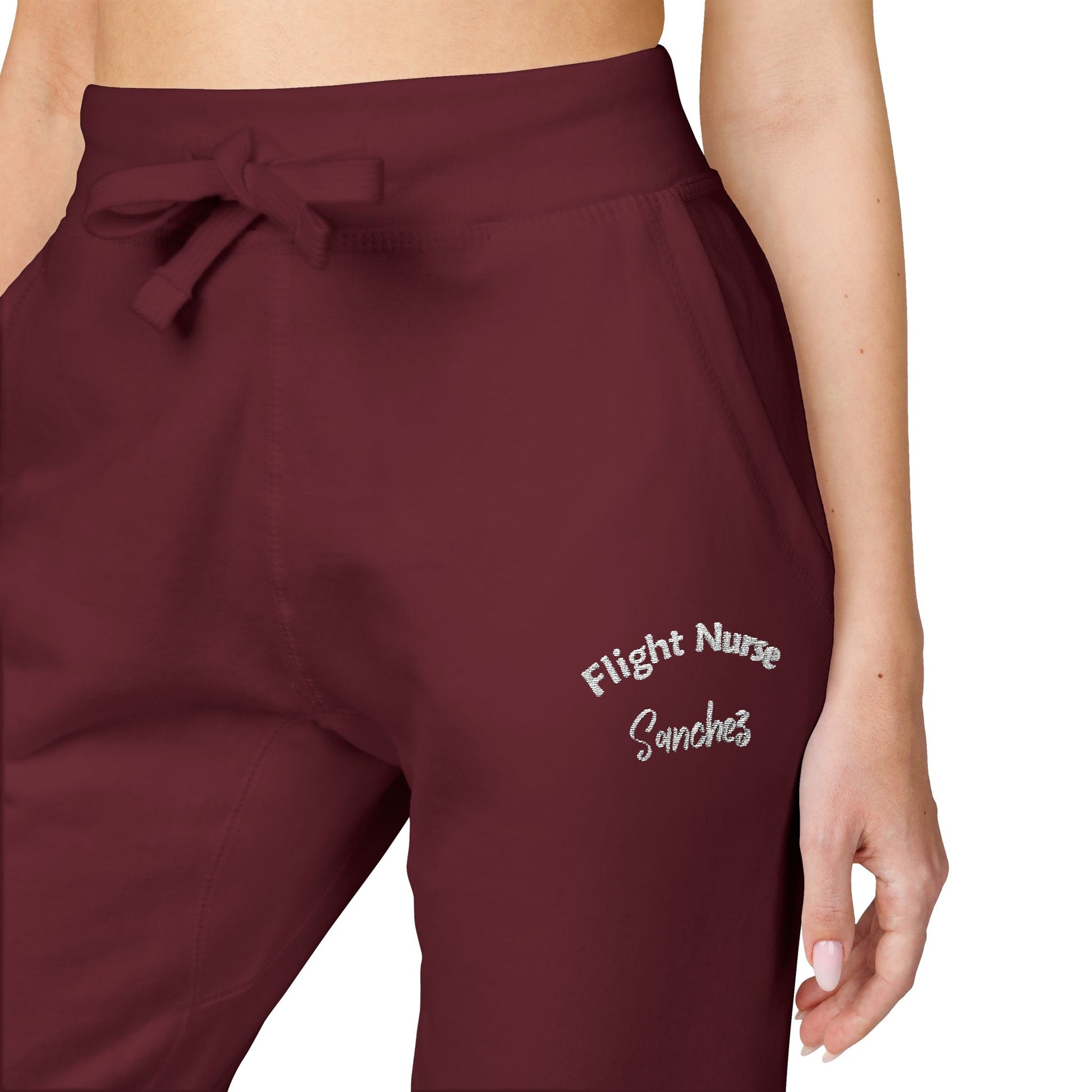 Maroon joggers with embroidered 'Flight Nurse Sanchez' text on the thigh against a white background