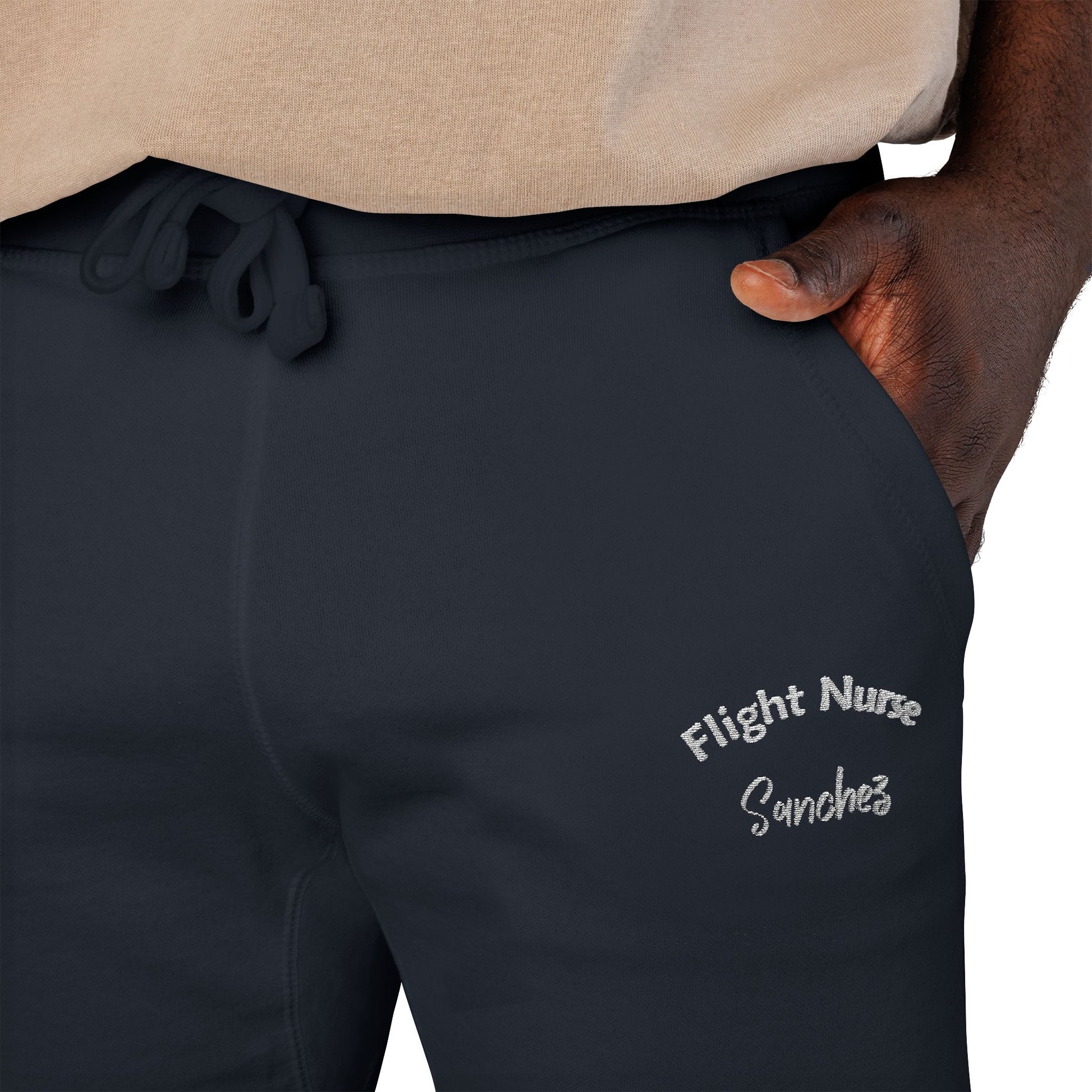 Black joggers with embroidered 'Flight Nurse Sanchez' text on the thigh against a white background