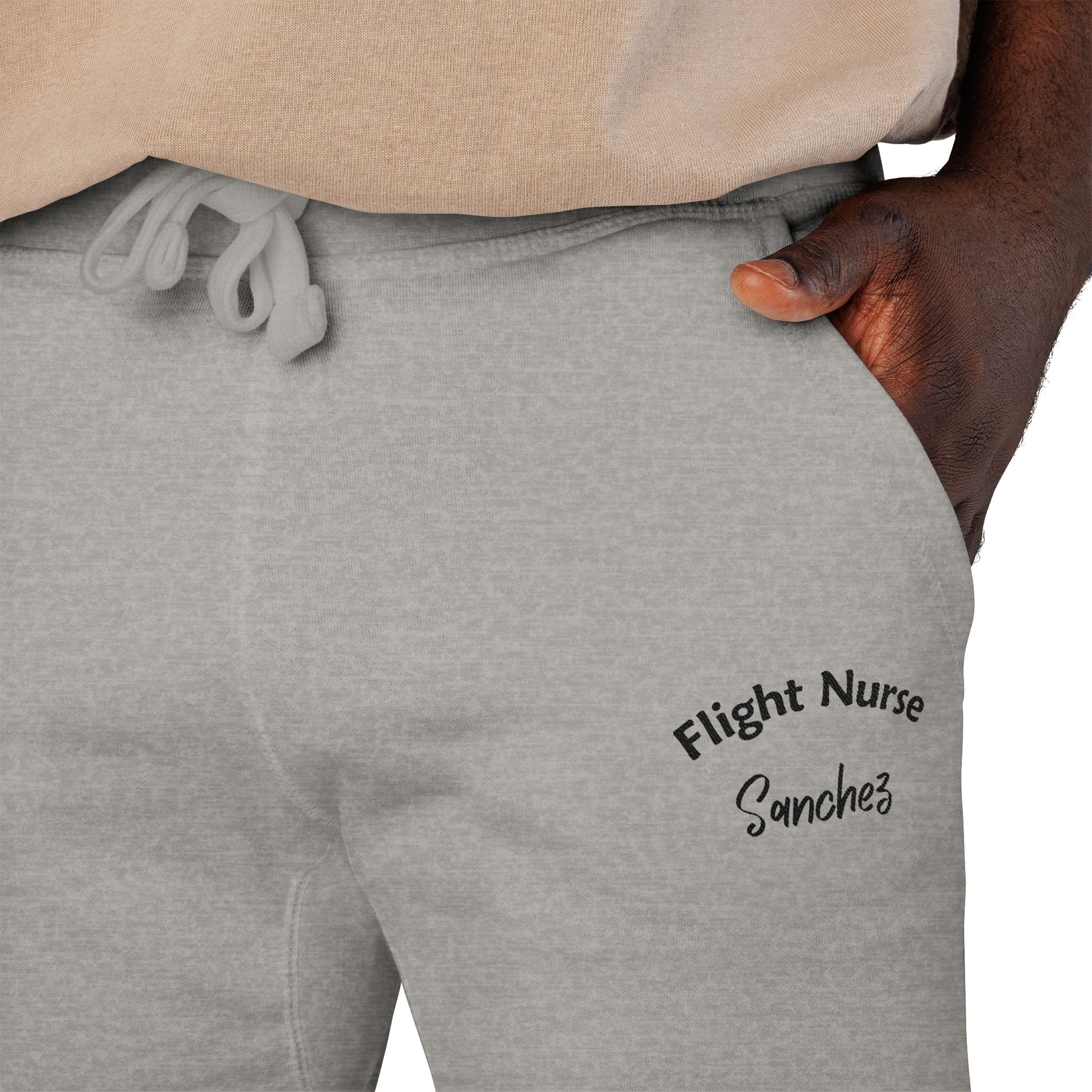 Gray joggers with embroidered 'Flight Nurse Sanchez' text on the thigh against a white background